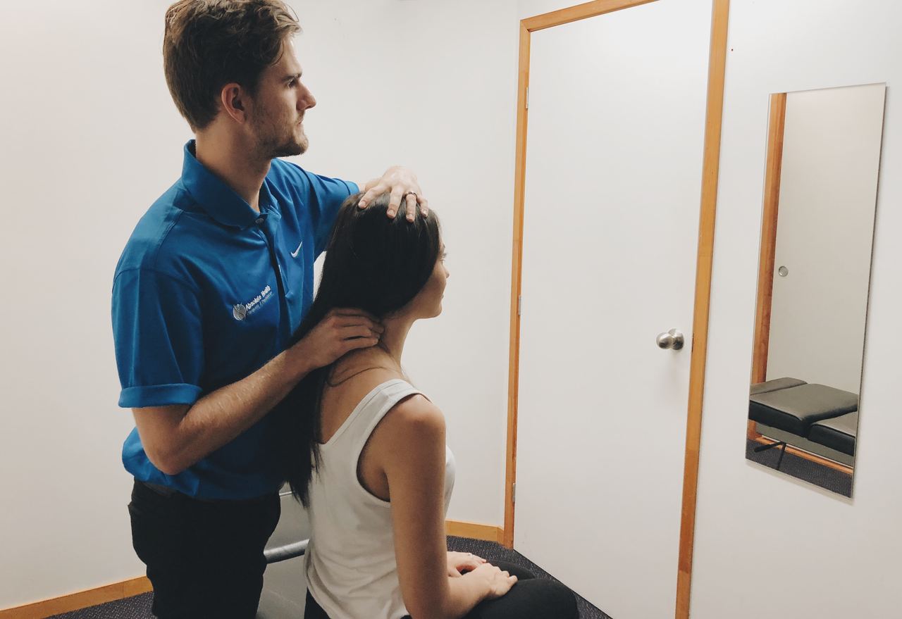 Chiropractor assessing cervical spine to treat headaches at Absolute Health Mooloolaba