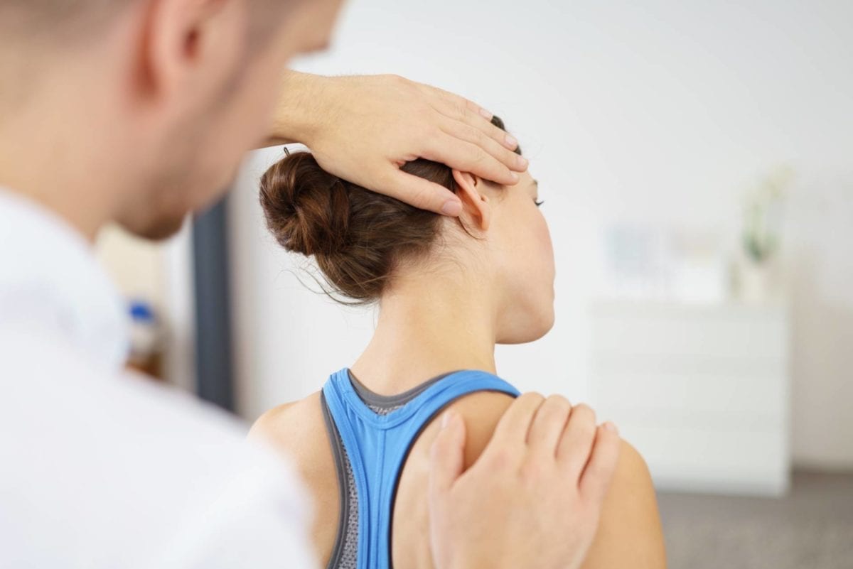 Practitioner treating a patient's neck and shoulder at Absolute Health